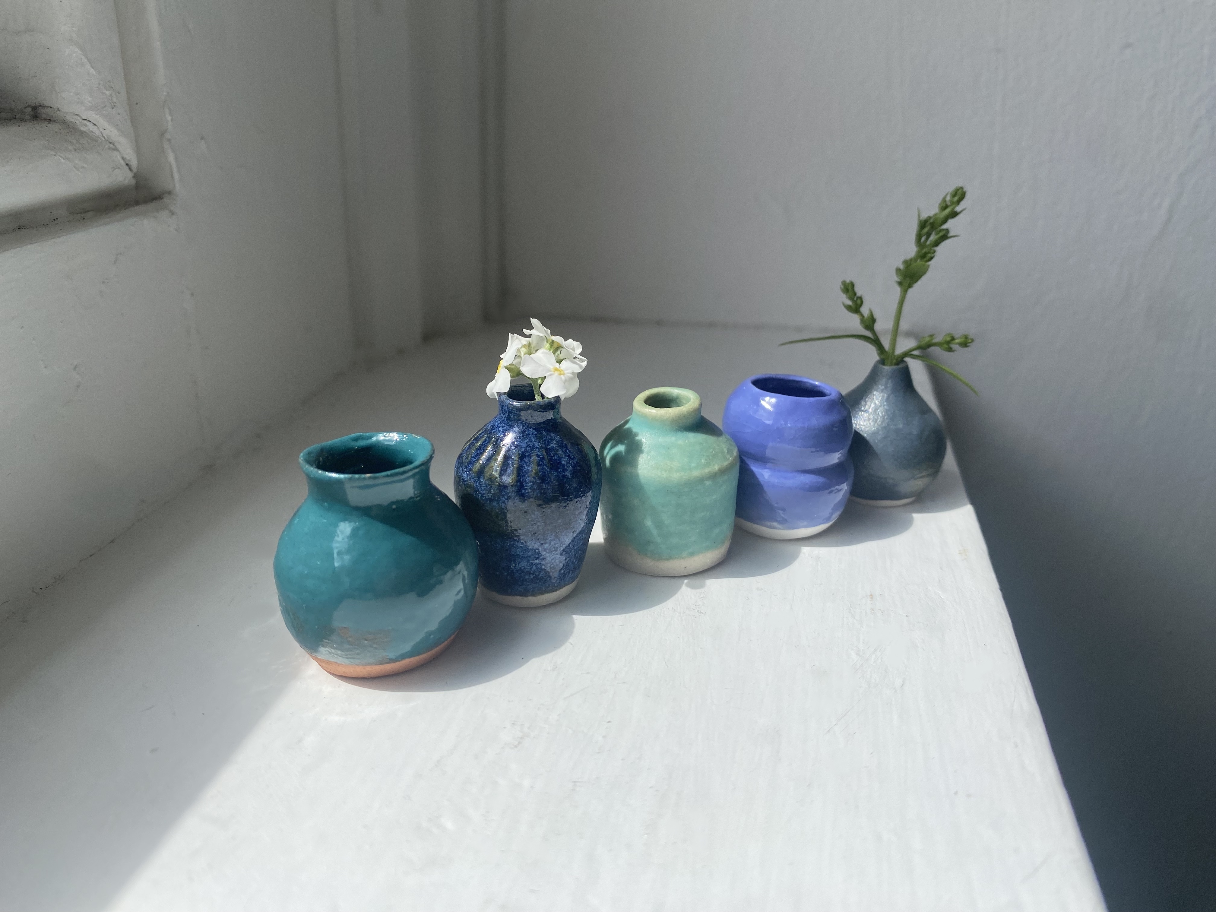 Tilly Slight, Blue miniature vase set. From left: Teal terracotta, Lagoon collar shapes I, Matt turquoise II, Satin blue I, Cobalt blue III. (5 pieces).